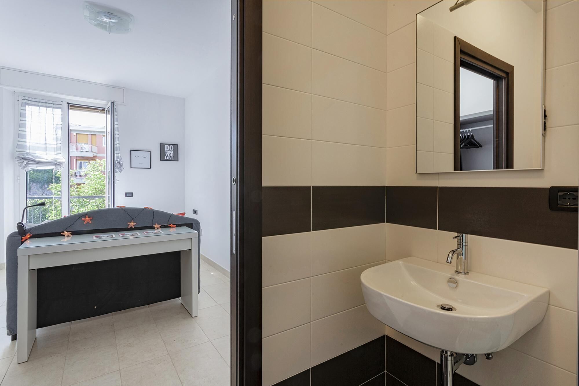 A modern bathroom with a white sink and dark tiles.
