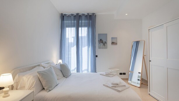 Ein Schlafzimmer mit einem Bett, einem Nachttisch und einem Spiegel.