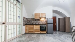 A kitchen with wooden cabinets, a built-in oven, and a refrigerator. - Apartment Manzoni 40 by Wonderful Italy (Catania)