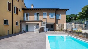 A two-story building with a swimming pool, a covered patio, and a staircase leading to the upper floor. - San Carlo Borromeo 3 by Wonderful Italy (Soiano del Lago)