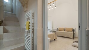 A staircase leading to a bedroom with a bed, a bedside table, and a window. - Casetta Biancapietra by Wonderful Italy (Ostuni)