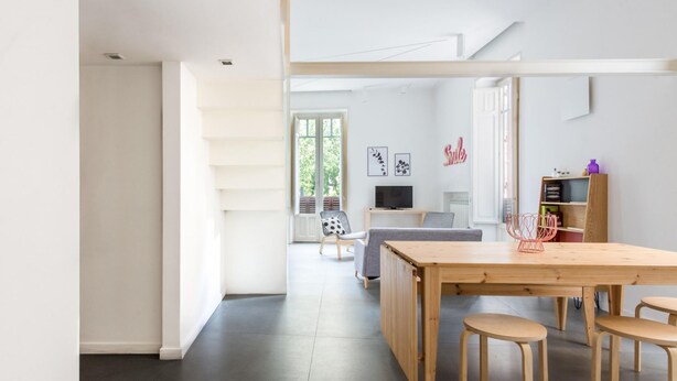 A modern, open-plan living space with a dining area, a sofa, a TV, and a bookshelf. - Casa Roma al Centro di Palermo by Wonderful Italy (Palermo)