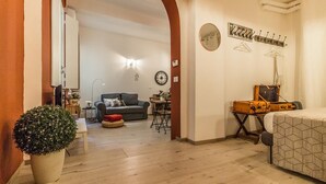 A living room with a sofa, a small table, a lamp, and a suitcase. - Corte Galluzzi in Basilica by Wonderful Italy (Bologna)