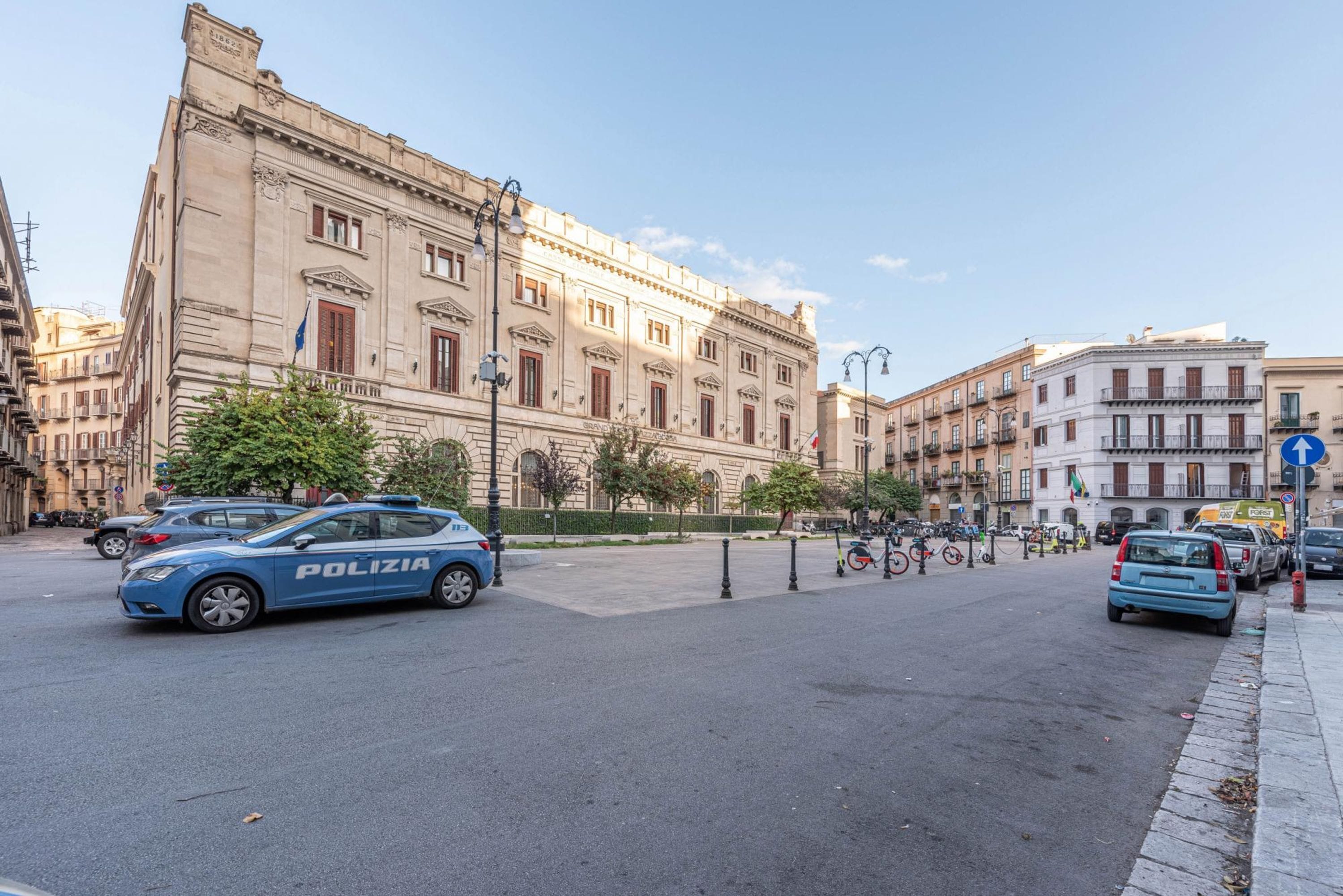 A street with a police car, buildings, and a clear sky.