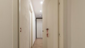 A narrow hallway with wooden flooring and white walls. - Casetta Borsa by Wonderful Italy (Palermo)