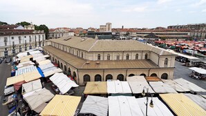 Ein großes Gebäude mit mehreren überdachten Marktständen davor.