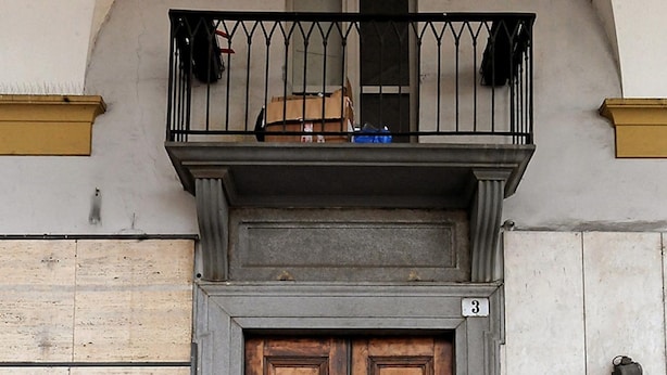 Eine zweiflügelige Holztür mit einem kleinen Balkon darüber.