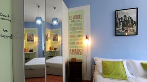 Ein Schlafzimmer mit Bett, Spiegel, Nachttisch und einer Wand mit motivierenden Texten.
