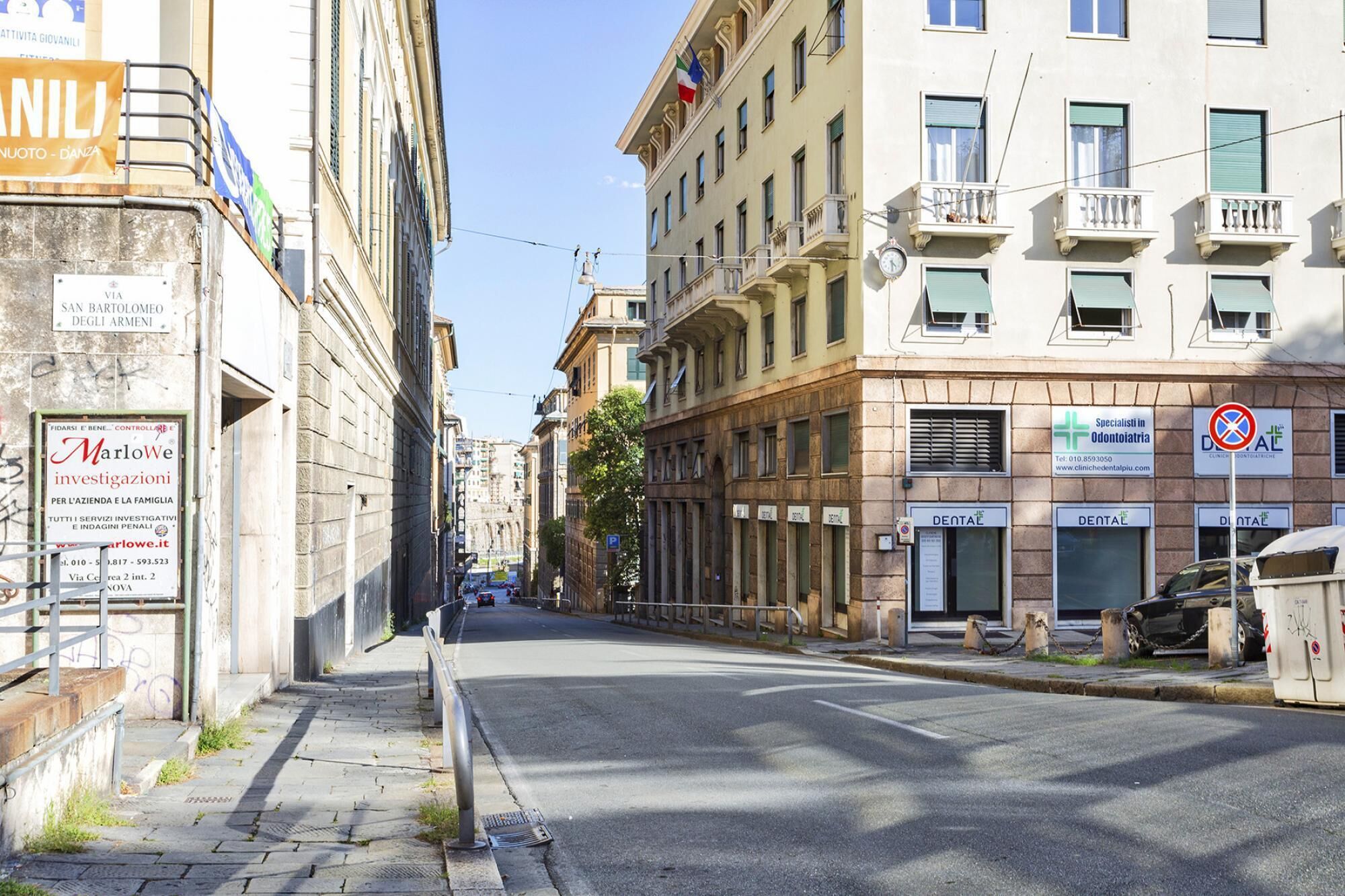 Una calle con edificios, incluyendo una clínica dental a la derecha.