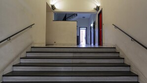 A staircase with handrails, leading to an open door at the top. - Modern Loft in the Center by Wonderful Italy (Genoa)