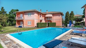A swimming pool with lounge chairs and a stone deck. - Il Quadrifoglio D4 con Piscina by Wonderful Italy (Sirmione)