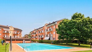 A residential building with a swimming pool, balconies, and a well-maintained lawn. - Maisonnette Il Todeschino B12 by Wonderful Italy (Sirmione)
