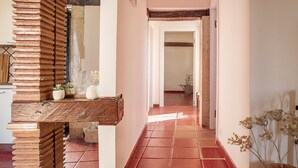 A hallway with red tiled flooring, a wooden bench with a rustic design, and a potted plant on the right. - Le Terrazze Dell Olivo by Wonderful Italy (Syracuse)