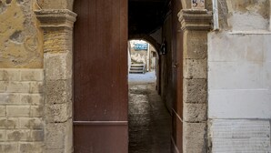 An arched corridor with a brick wall on one side and a tiled wall on the other, leading to a staircase. - Le Terrazze Dell Olivo by Wonderful Italy (Syracuse)