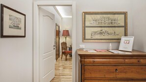 A hallway with a wooden dresser, framed artwork, and a door leading to another room. - Marvelous Soziglia Apartment by Wonderful Italy (Genoa)