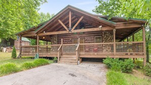 Un rustico chalet con portico, travi in legno e fondamenta in pietra.