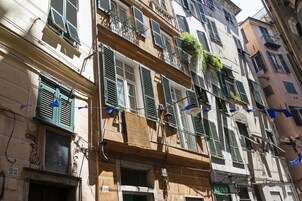 Un edificio de varios pisos con balcones, una tienda visible en la planta baja y un letrero que indica una cafetería.
