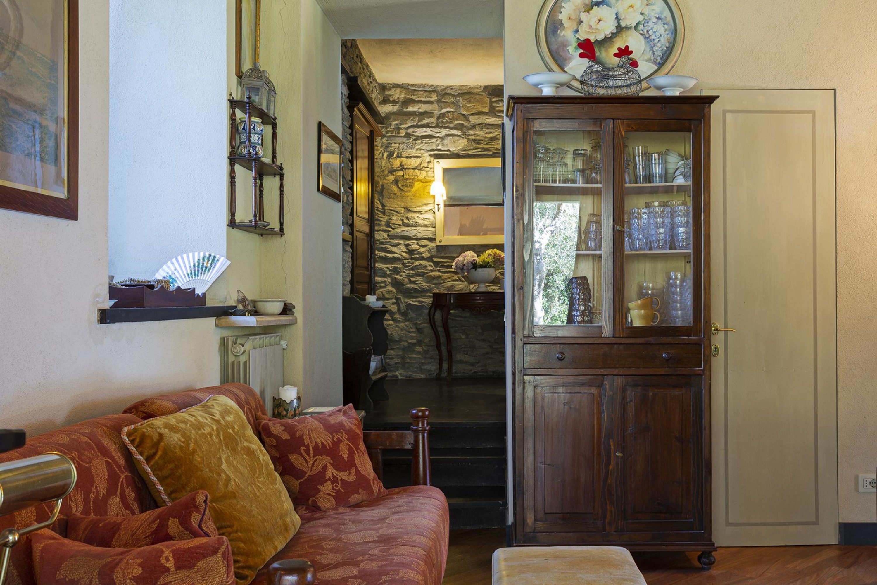 A cozy living room with a wooden cabinet, a stone wall, and a fireplace.