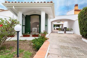 A covered patio with outdoor seating, a garden with potted plants, and a clear sky. - Villino a Fontane Bianche by Wonderful Italy (Syracuse)