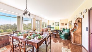 A spacious dining area with a wooden table set for a meal, surrounded by chairs.