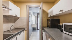 A compact kitchen with a microwave, toaster, and sink. - Ursino Apartment With Balcony by Wonderful Italy (Catania)
