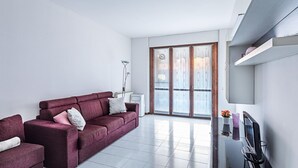 A modern living room with a sofa, a coffee table, and a flat-screen TV. - Artemisia B 1 con Piscina by Wonderful Italy (Sirmione)