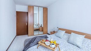 A bedroom with a bed, bedside table, and a tray with breakfast items. - Artemisia B 1 con Piscina by Wonderful Italy (Sirmione)