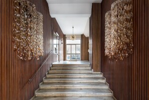 A staircase with wooden paneling on both sides and a chandelier at the top. - Design and Comfort in the Heart of Catania by Wonderful Italy (Catania)