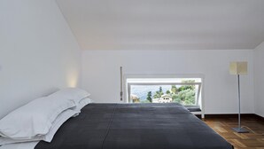 A bedroom with a bed, a window, and a floor lamp. - Casa Bianca a Bogliasco by Wonderful Italy (Bogliasco)