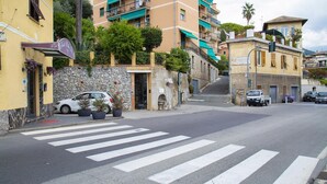 A street view with a crosswalk, parked cars, and buildings with balconies and greenery. - Casa Bianca a Bogliasco by Wonderful Italy (Bogliasco)