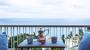 A balcony with a table set for tea, a teapot, and two cups, overlooking a coastal view. - Casa Bianca a Bogliasco by Wonderful Italy (Bogliasco)