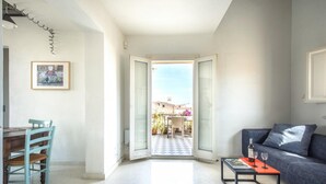 Una sala de estar con comedor, un sofá, una mesa de centro y vistas al exterior.