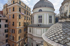 A historic building with a dome and a bell tower, featuring multiple windows and balconies.
