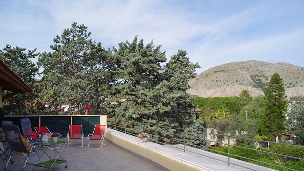 A terrace with outdoor seating, a mountain view, and a railing. - Villa Flores a Mondello by Wonderful Italy (Palermo)