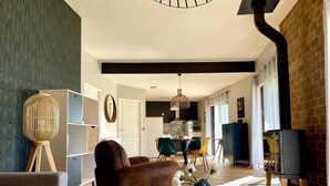 A modern living room with a sofa, a round coffee table, and a dining area with chairs and a table. - Gites-domainedupin, cottage "Mosnes à Lisa" (Mosnes)