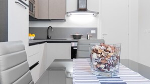 A modern kitchen with a glass vase of nuts on a striped tablecloth. - Loft del Conte nei Pressi Della Mole by Wonderful Italy (Turin)