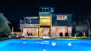 Ein zweistöckiges Haus mit Schwimmbecken davor.