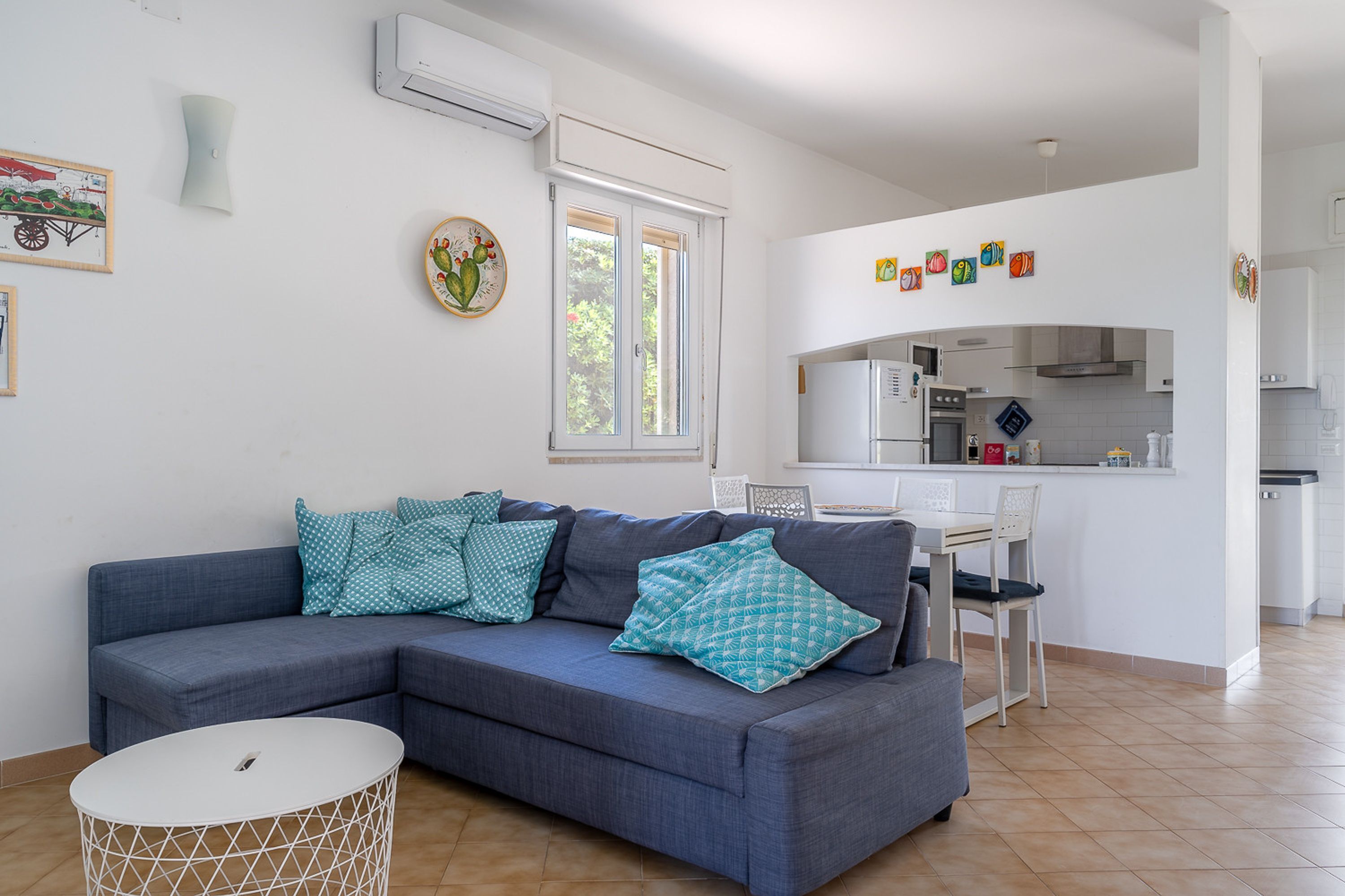 Een moderne woonkamer met een hoekbank, een eettafel en een keuken op de achtergrond.