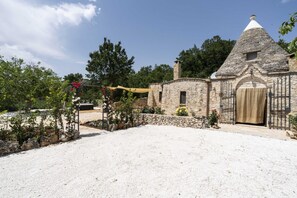 A stone building with a conical roof, a wooden door, and a small window.