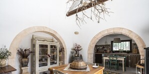Traditional kitchen with exposed brick walls, stone archways, and a wooden table.
