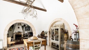 A rustic interior with exposed wooden beams, stone arches, and a traditional wooden table. - Trullo Fragno by Wonderful Italy (Noci)