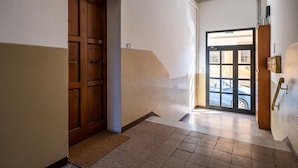 Um corredor com porta de madeira e porta de vidro que dá para o exterior.