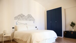 A bedroom with a bed, a chair, a wardrobe, and a potted plant. - Casa Mil by Wonderful Italy (Naples)