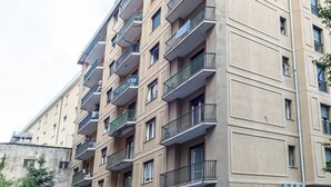 A multi-story residential building with balconies, air conditioning units, and a beige facade. - Corsica Boutique Apartment 8 by Wonderful Italy (Genoa)