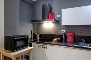 Uma cozinha moderna com micro-ondas embutido, exaustor e pia.