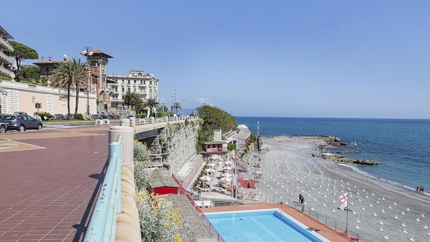 A coastal hotel with a pool, beach access, and a view of the sea.