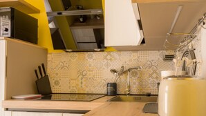 A compact kitchen with a modern design, featuring a sink, a coffee maker, and a kettle. - Fossalta Vintage Apartment by Wonderful Italy (Bologna)