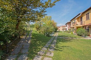 Stroll through the beautifully maintained garden, lined with a stone pathway and surrounded by lush trees and shrubs.