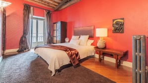 A bedroom with a wooden ceiling, a bed with a headboard, a bedside table with a lamp, and a radiator. - A Due Passi Dalla Mole by Wonderful Italy (Turin)
