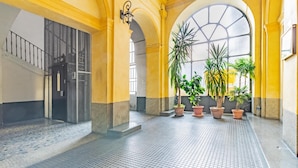 A spacious indoor area with tiled flooring, yellow walls, and large windows. - A Due Passi Dalla Mole by Wonderful Italy (Turin)